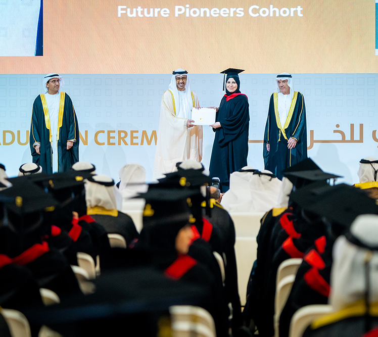 طالبان بالزي التقليدي يجلسان على مقعد في الحرم الجامعي ويراجعان المحتوى على جهاز لوحي