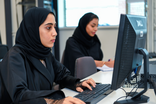 امرأتان تعملان على أجهزة كمبيوتر مكتبية في بيئة مكتبية في خدمات دعم تقنية المعلومات (ITSS) بجامعة الإمارات العربية المتحدة.